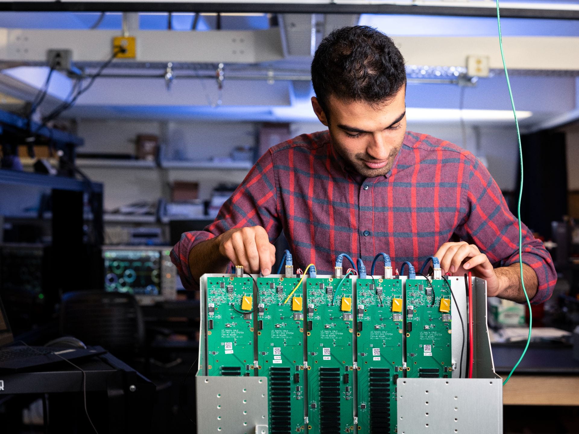 Male student behind circuit board